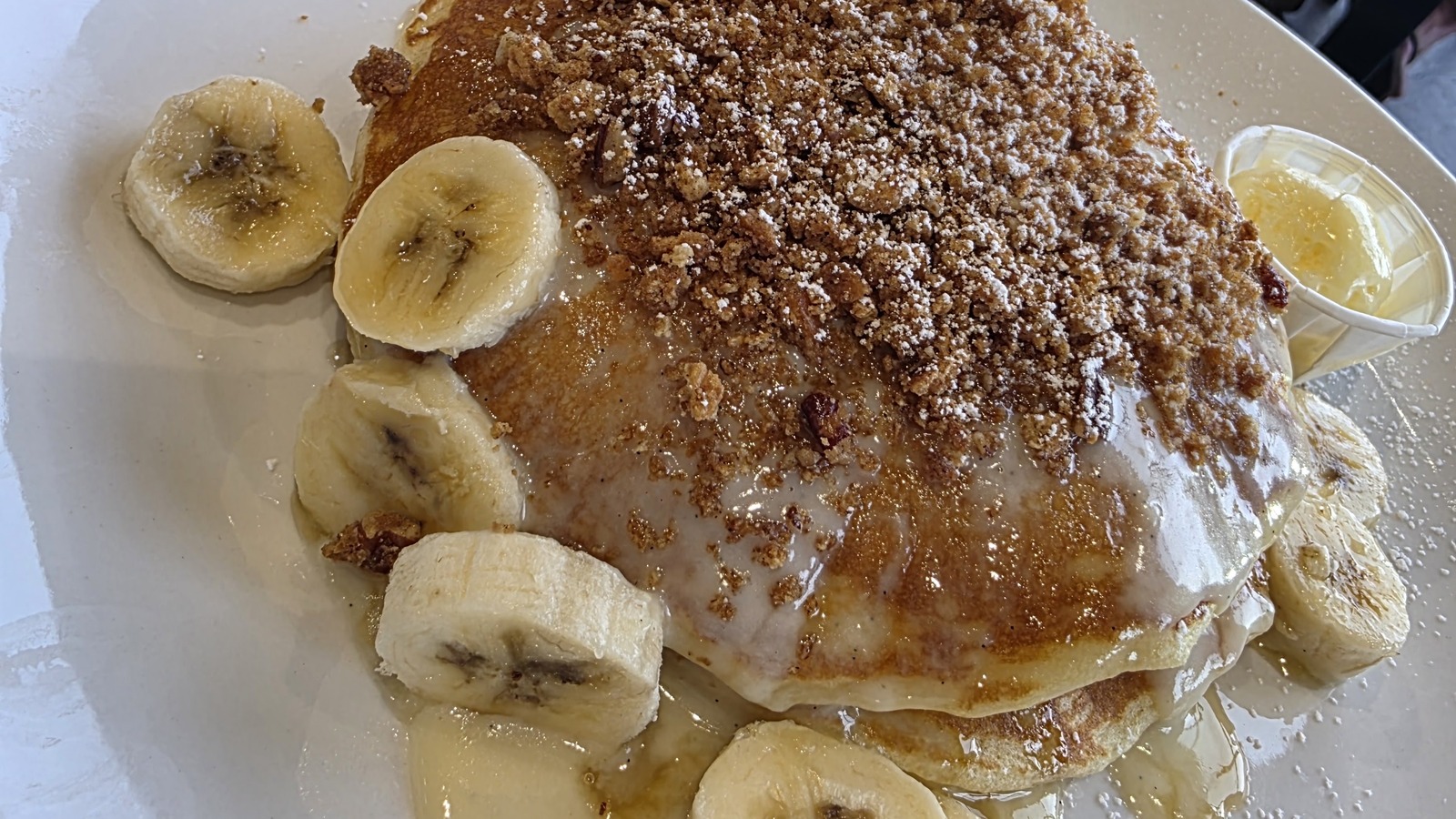 Banana-topped pancakes with powdered sugar at Butters Pancakes & Cafe