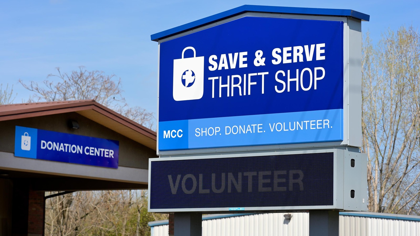 Blue Save and Serve Thrift Shop sign beside its Millersburg donation center