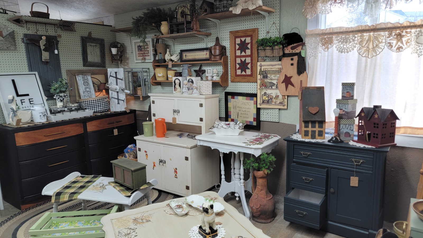 Painted furniture, quilts, and vintage decor in a Snoopers Antique Mall vendor room