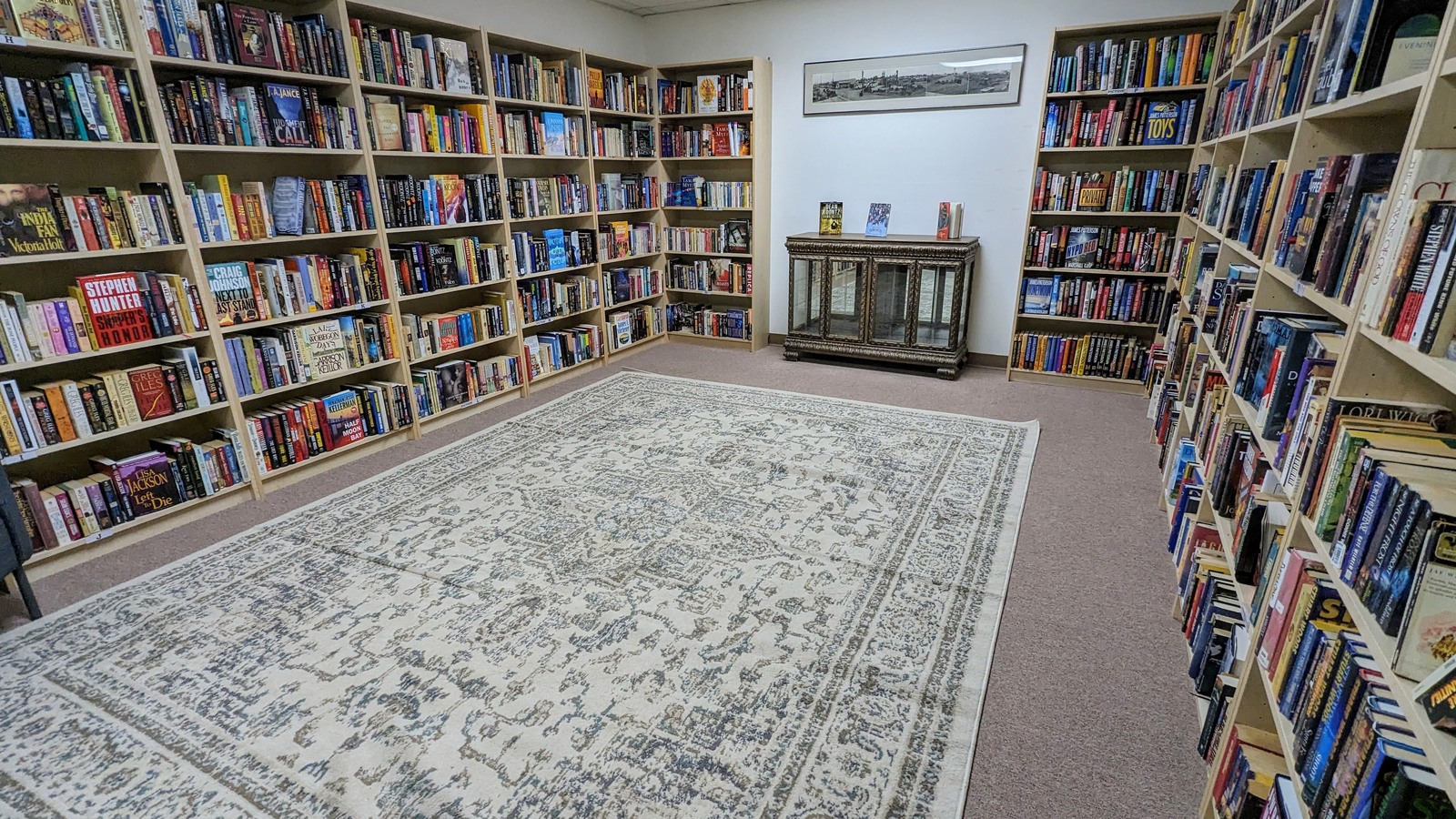 Wall-to-wall used books arranged around a reading room at Still Fond and More