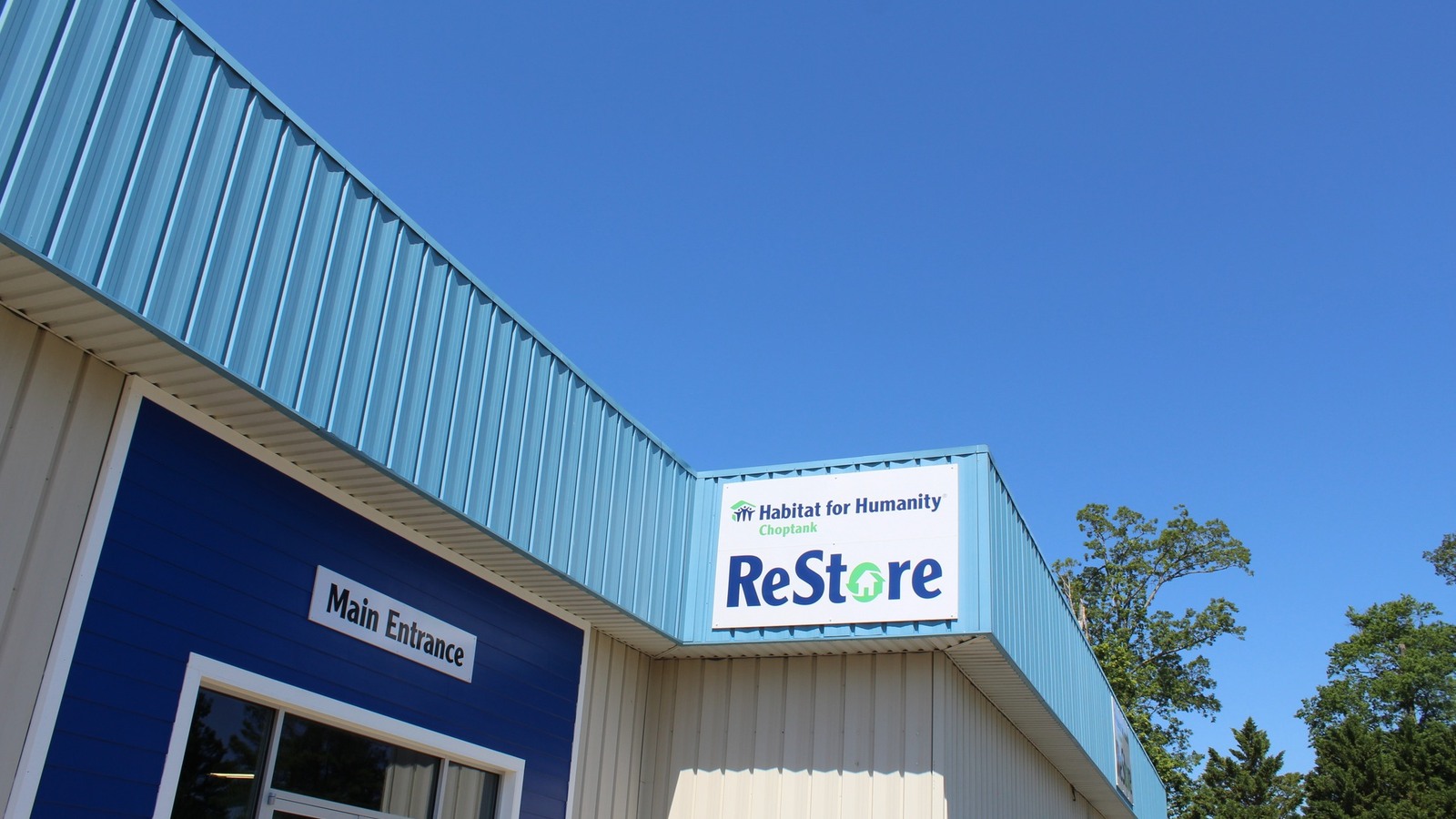 Blue Habitat for Humanity Choptank ReStore building beneath a clear Easton sky