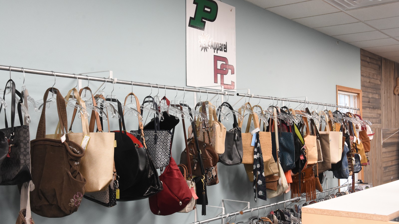 Handbags arranged along a display wall at Deja Vu Consignments in Pella