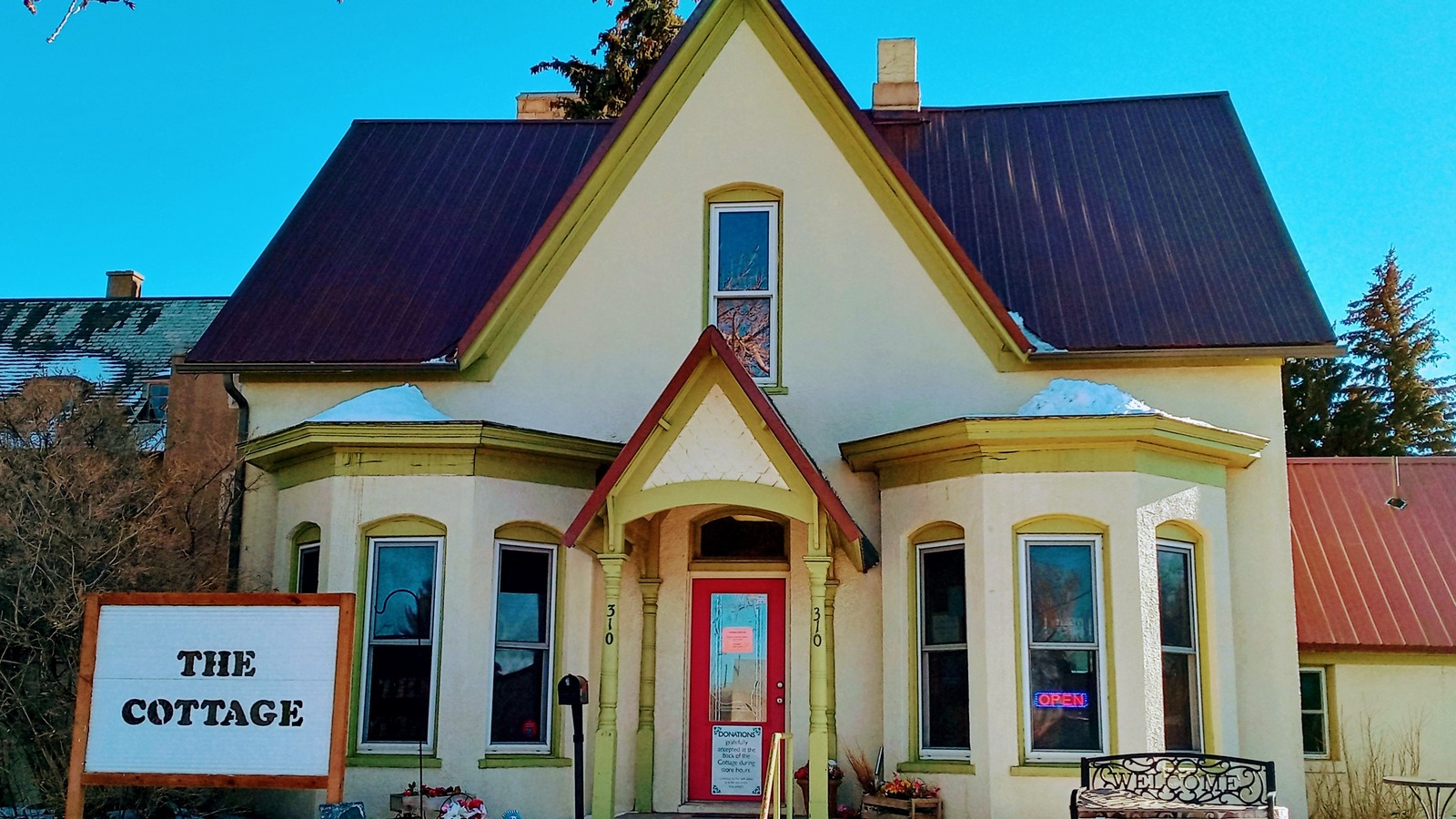 Historic house and colorful entrance of the Clothing Cottage at St. Matthew's in Laramie
