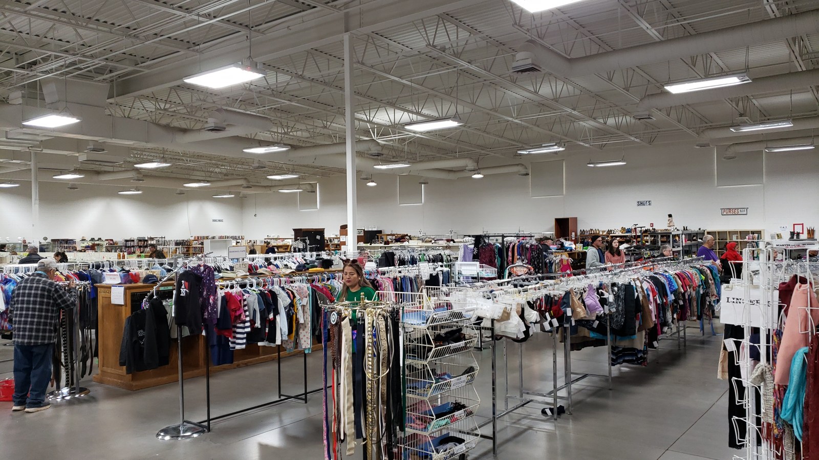 Long clothing racks inside White Elephant thrift store in Green Valley