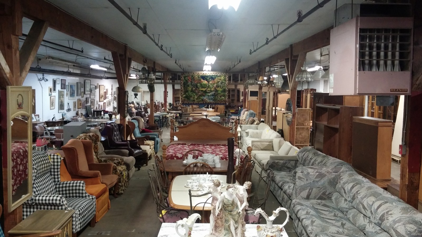Large furniture room filled with tables, chairs, sofas, and cabinets at Sweet Repeats
