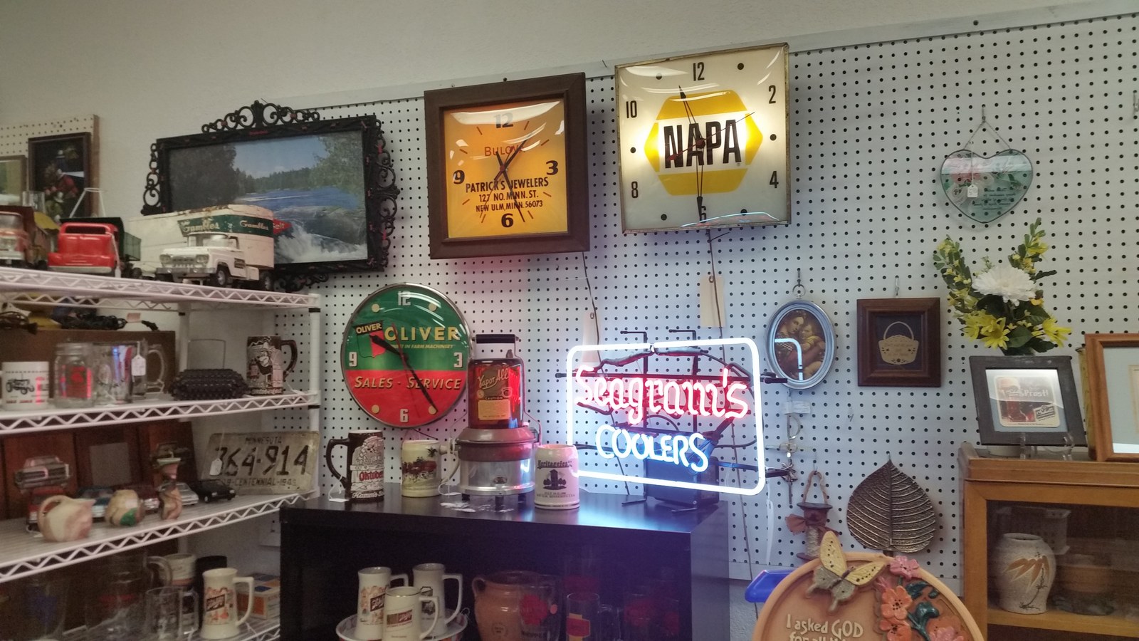 Vintage signs, clocks, and decor arranged inside Antiques Plus in downtown New Ulm