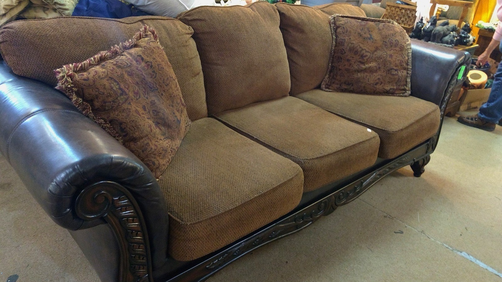 Rolled-arm loveseat and accent pillows inside Second Hand Rose Furniture in Ashland