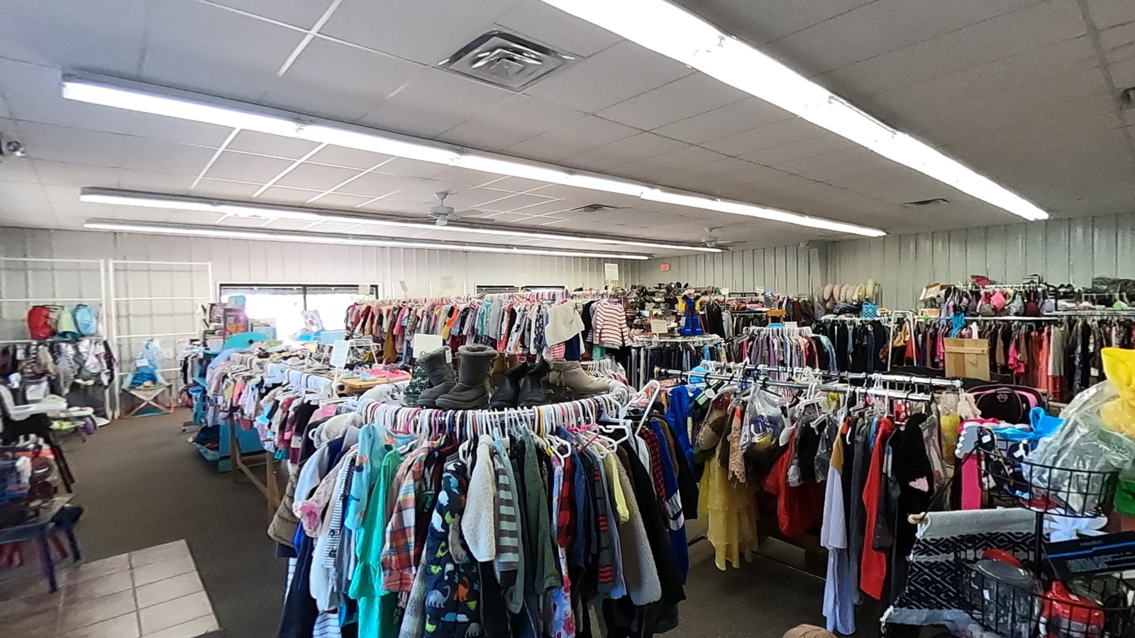 Children's clothing racks, strollers, and baby gear inside Little Darlings in Bentonville