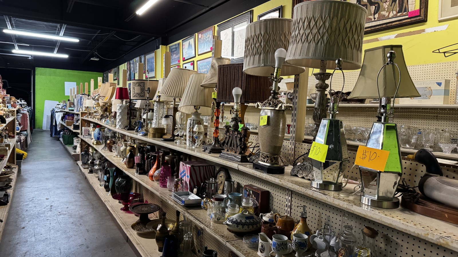 Lamps and glassware lined up inside Rags To Riches Thrift Store in Stuart