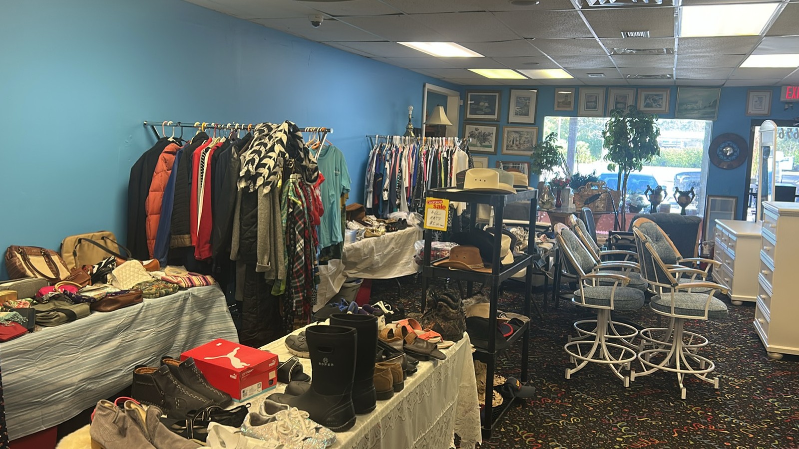 Clothing racks, chairs, and accessories inside Wall 2 Wall Thrift in Stuart