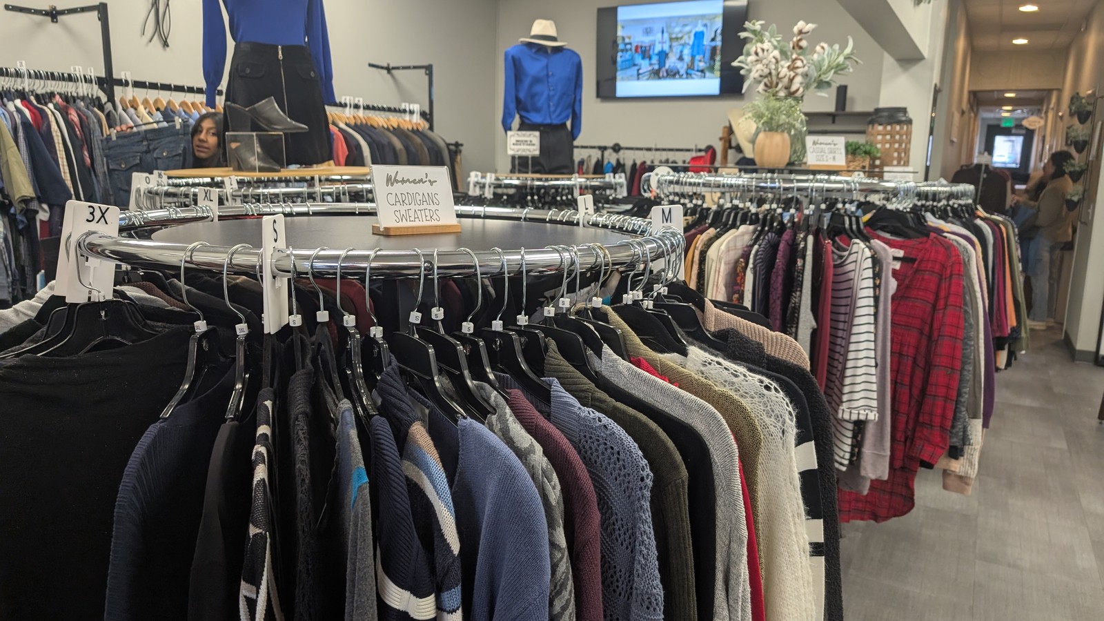 Organized sweater racks and displays inside Elevated Communities Gently Used Clothing Boutique in Longmont Colorado