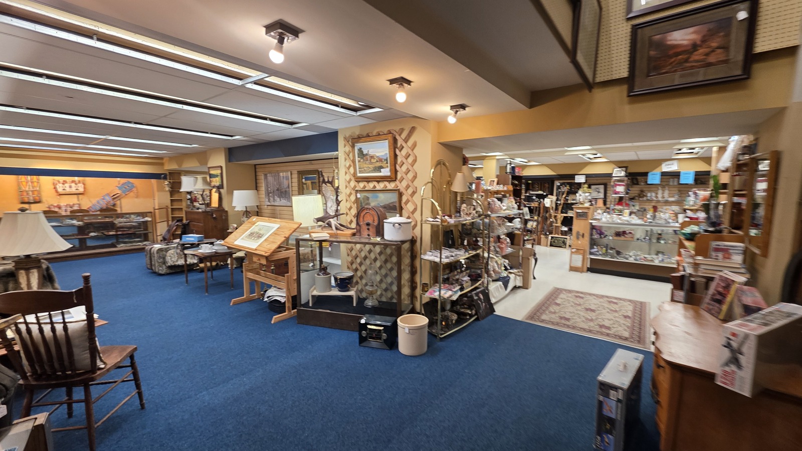 Open showroom with antiques, lamps, and display cases inside Best Out West Antiques in Sheridan