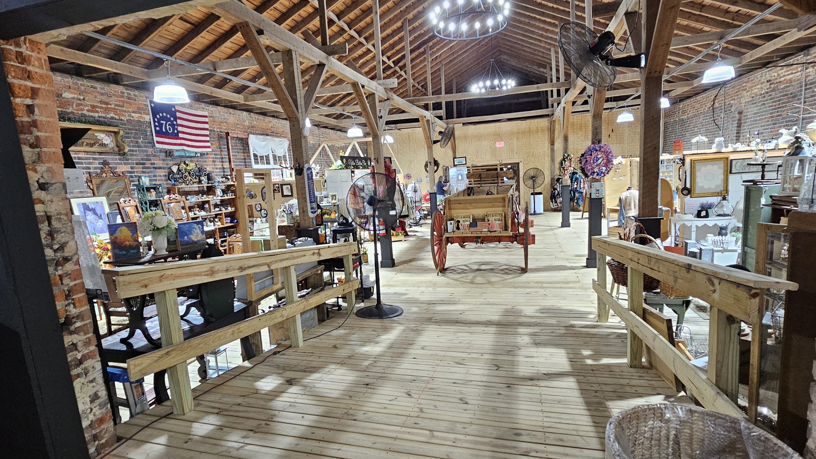 Open timber-framed barn interior with vendor booths inside Miss Lilly's Trading Post in Suffolk