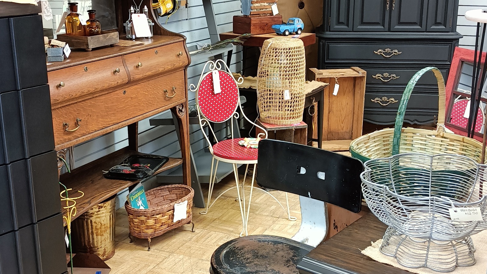 Vintage furniture, baskets, and colorful accent chairs inside Vintage Junky in Forest Lake