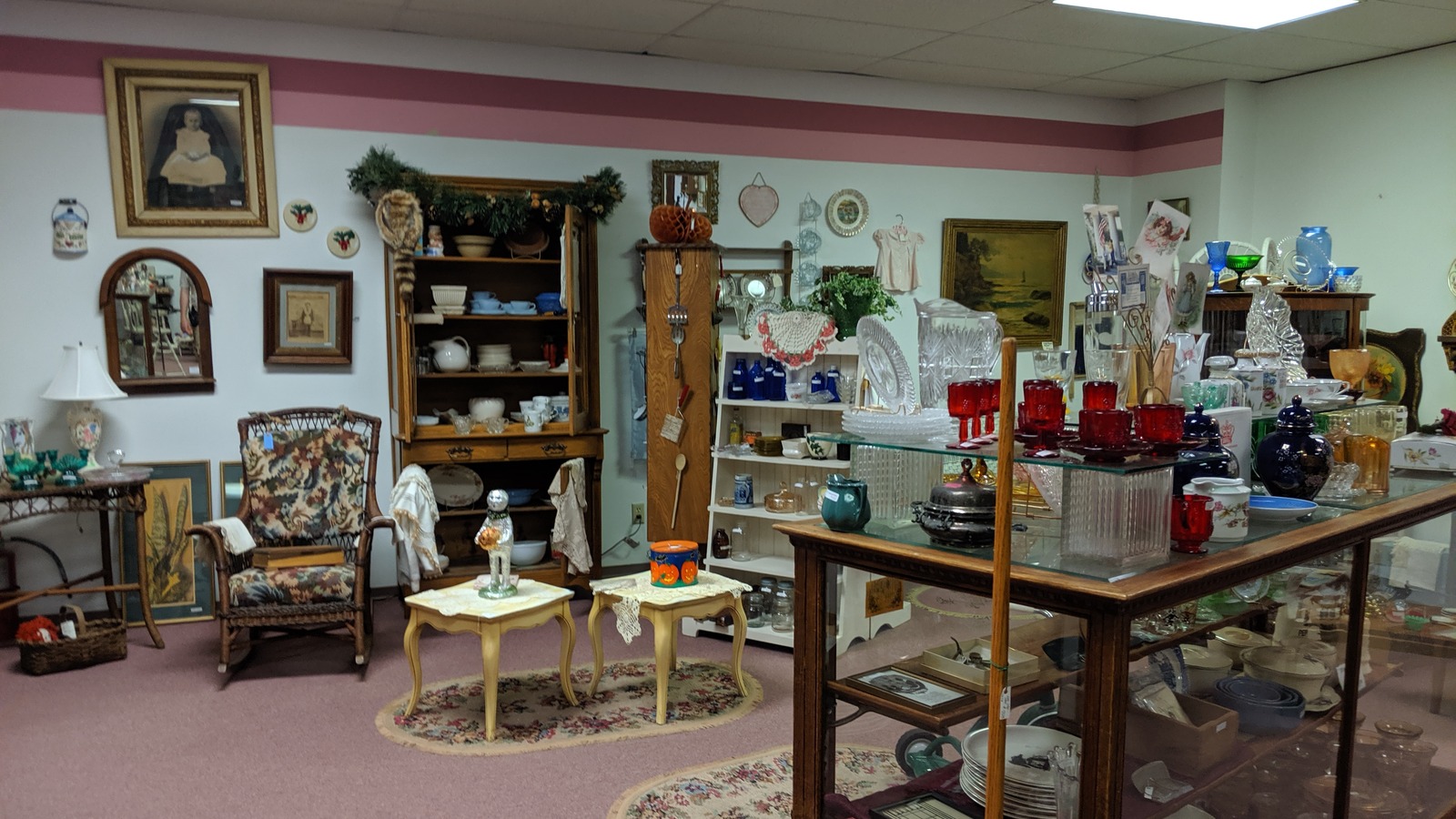 Glassware, furniture, and framed art inside Antique Mall of Hays