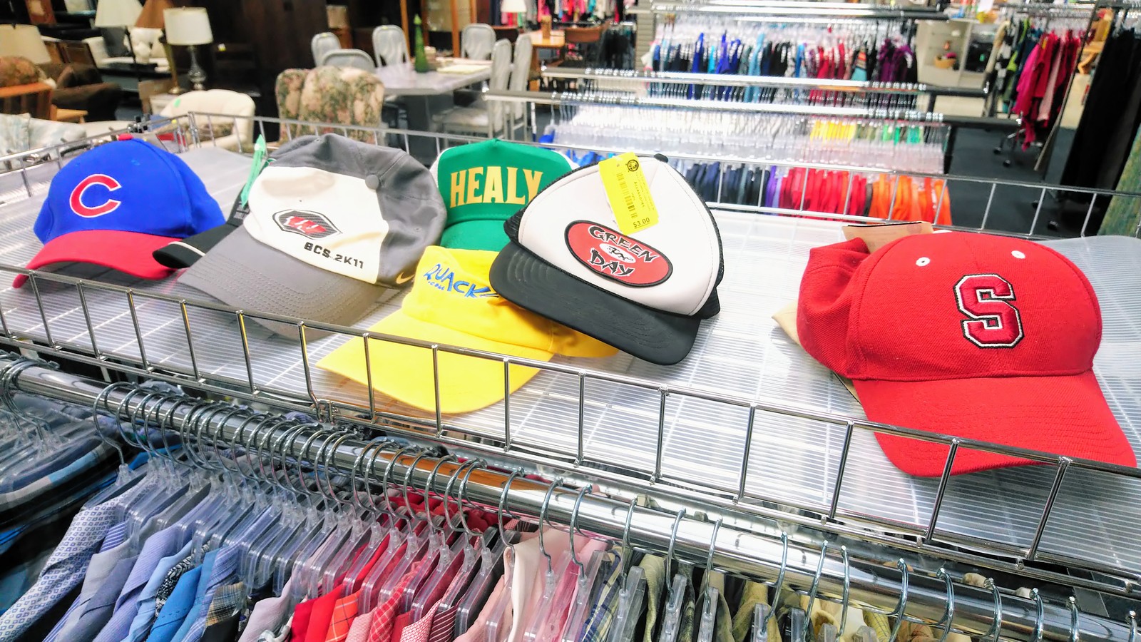 Clothing racks and sports caps inside St Vincent de Paul Thrift Store in Pleasant Hill California